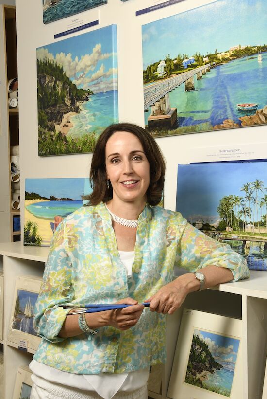 A person stands in an art gallery surrounded by scenic landscape paintings, holding a brush. The atmosphere is vibrant and creative.